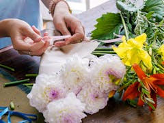 One of our designers carefully arranges a variety of mixed flowers