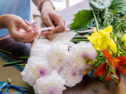 One of our designers carefully arranges a variety of mixed flowers